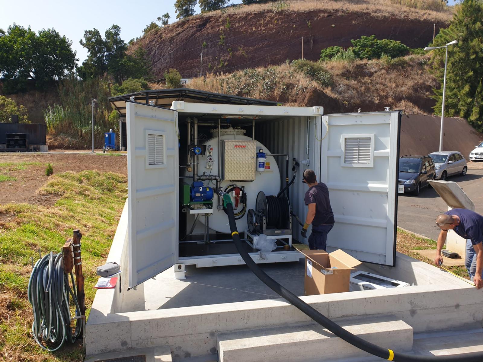 Crew installing a tanked containerized fuel system on a concrete base