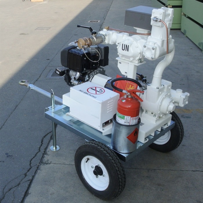 Close-up of a white UN-marked fuel transfer pump unit with fire extinguisher