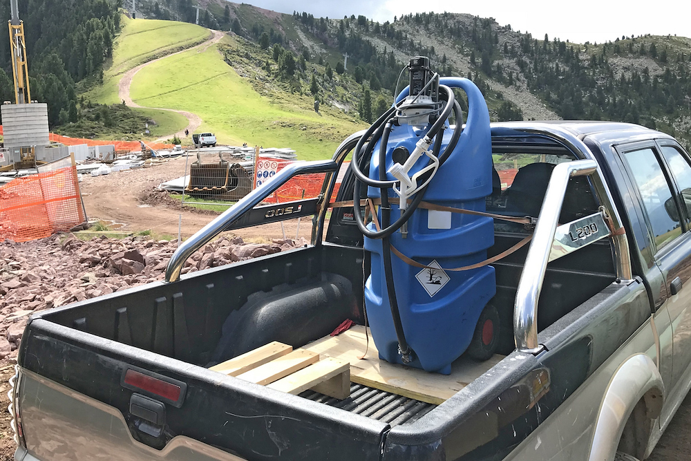 Portable DEF caddy secured in a pickup bed at a mountain construction site