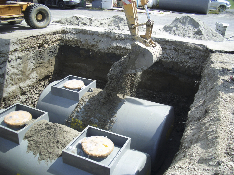 Underground tanks set in an excavation during backfill installation