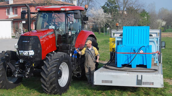Trailer-mounted DEF tank refuelling a tractor in the field