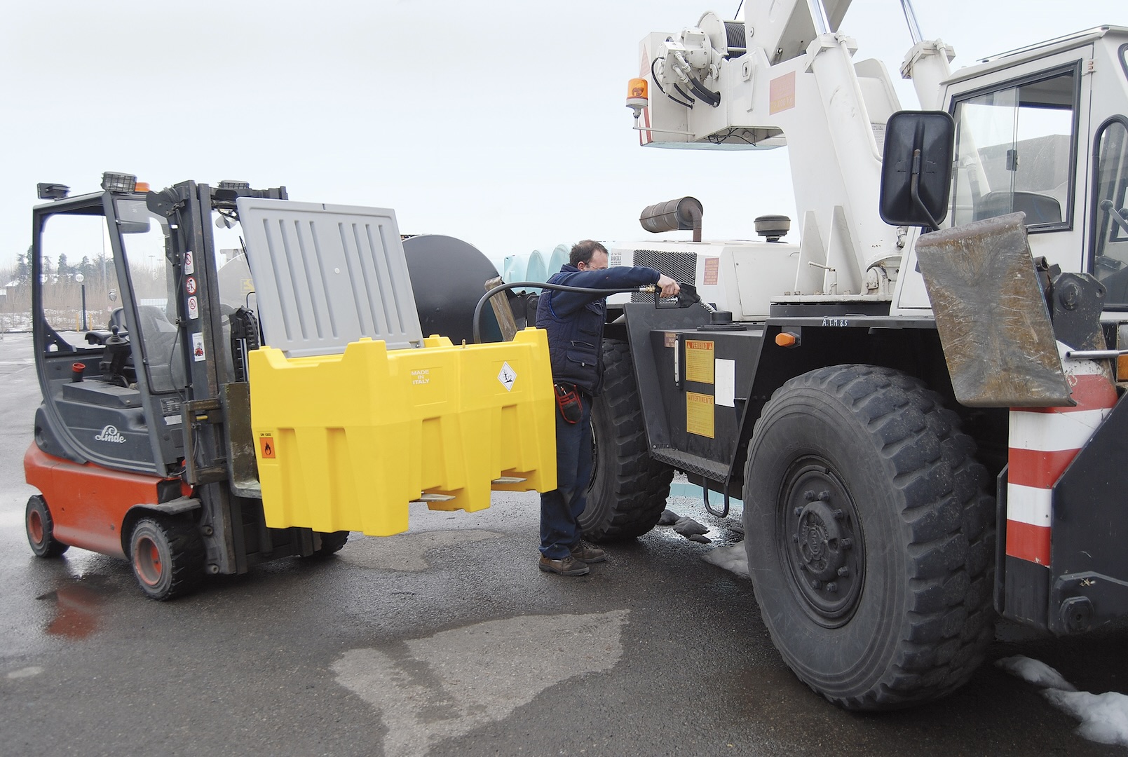 Forklift-handled bunded transportable tank refueling a mobile crane